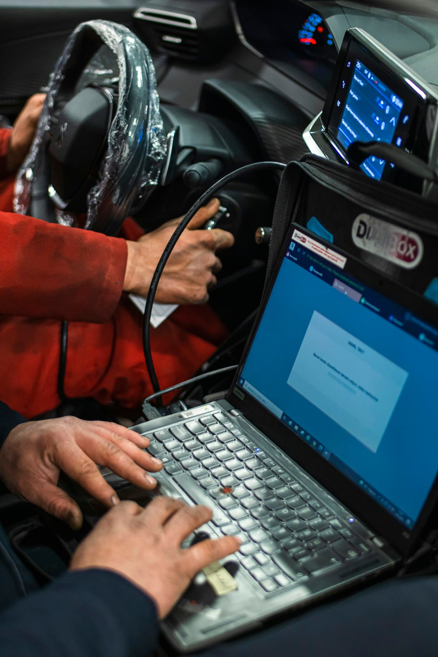 Técnico conectando un equipo de diagnosis por ordenador a un coche