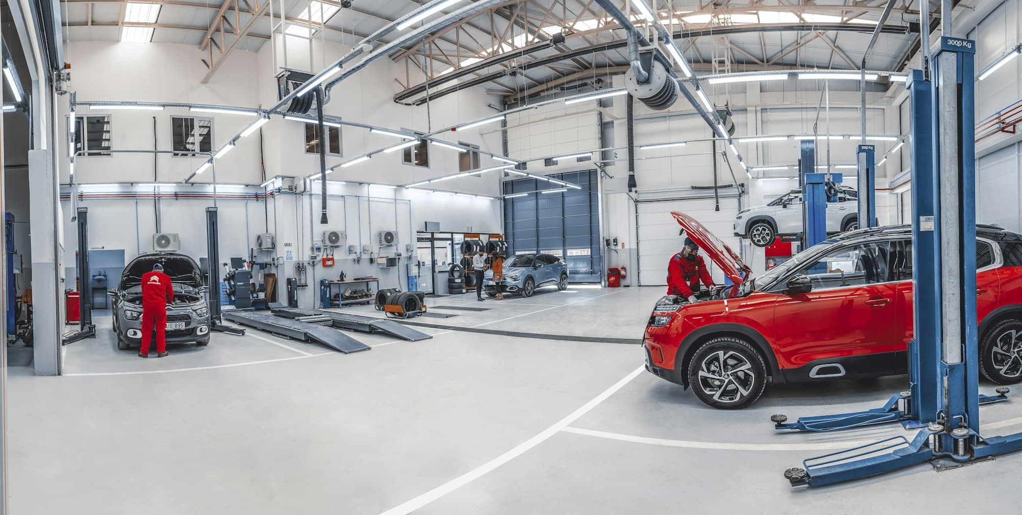 Mecánicos trabajando en varios coches dentro de un taller