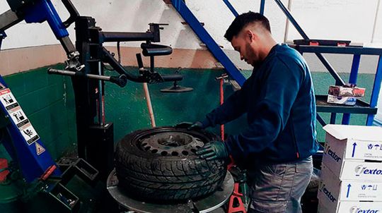 Autos Ragza, S.L. hombre reparando neumático